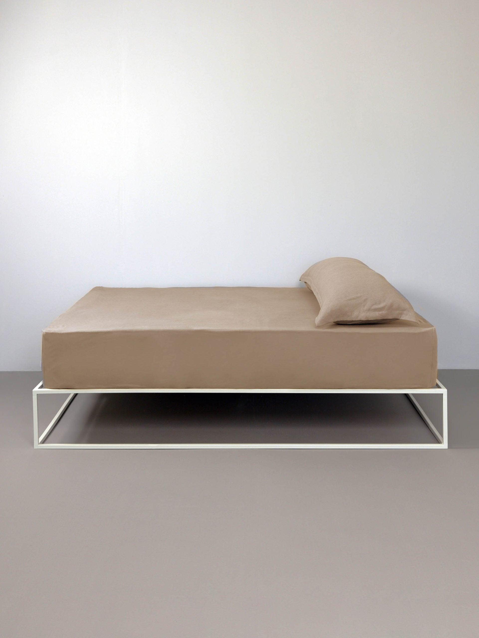 סדין ג'רסי טריקו וכרית עם ציפית לכרית בצבע מוקה על מיטת ברזל לבנה