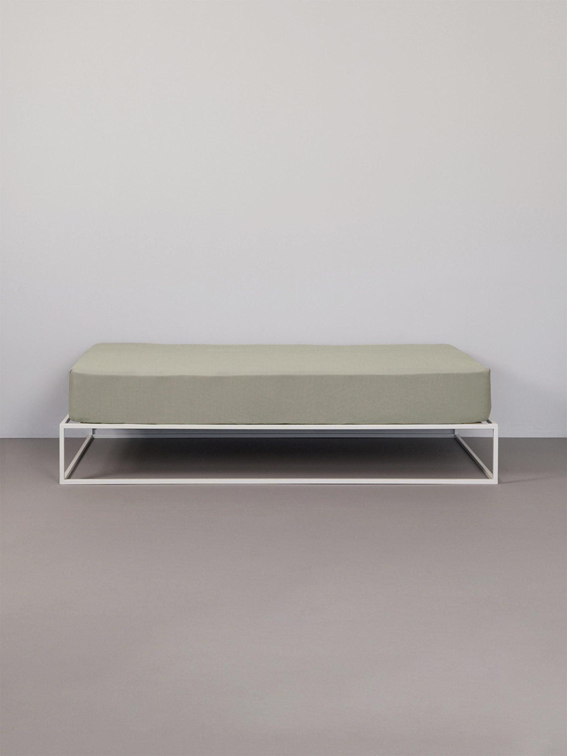 סדין ג'רסי טריקו בצבע מוקה על מיטת ברזל לבנה