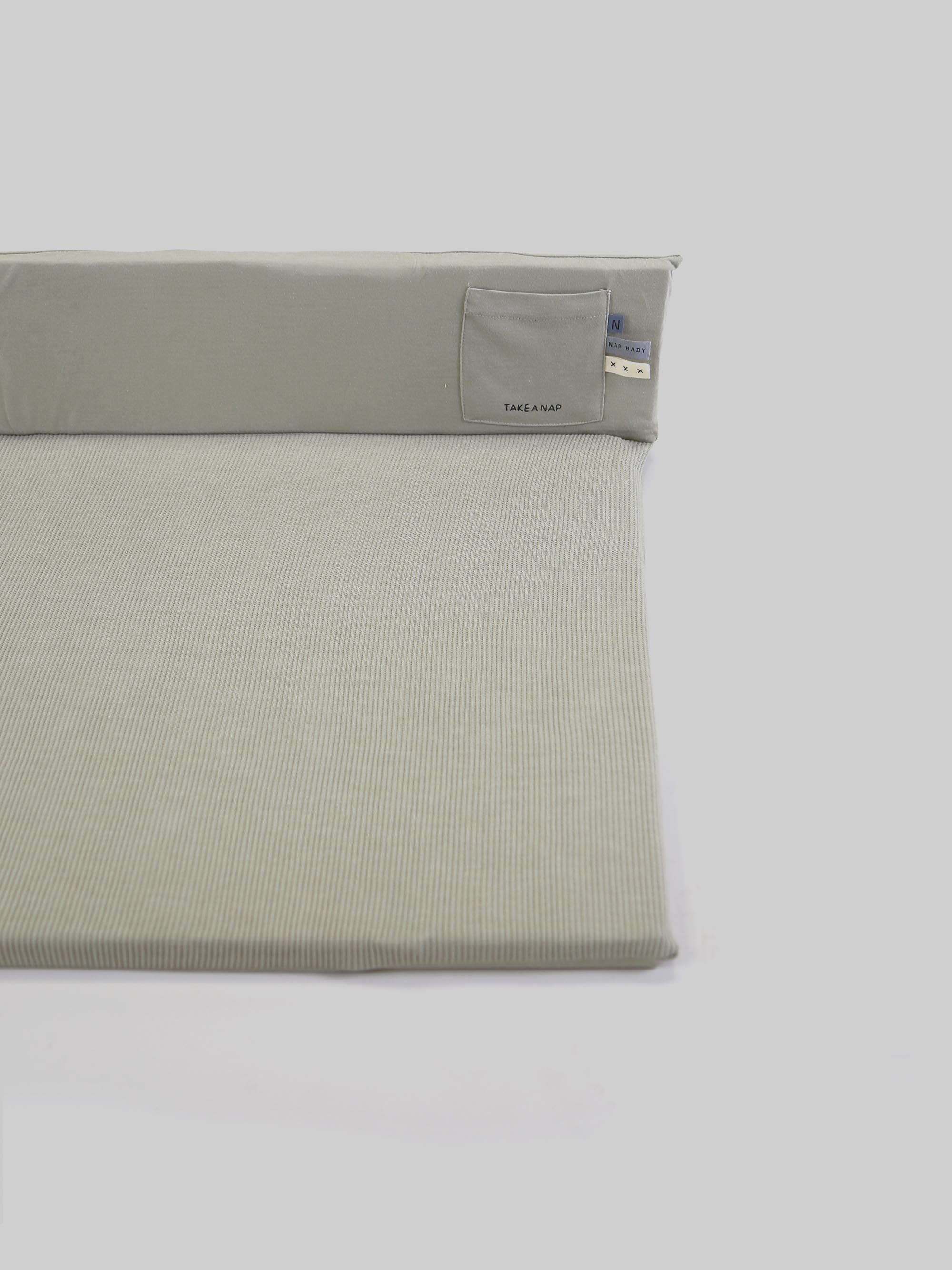 משטח החתלה בצבע פיסטוק על רקע אפור