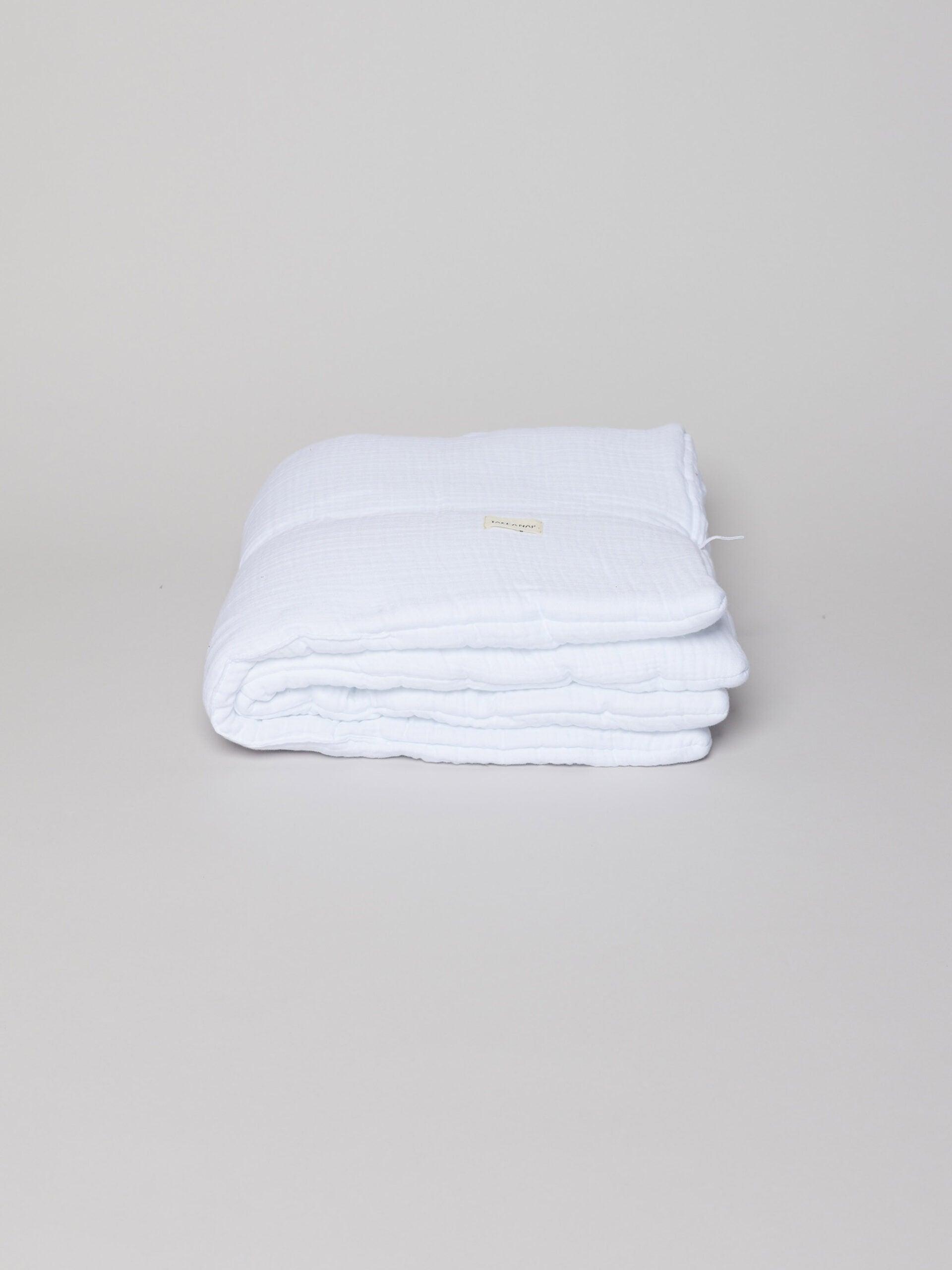 שמיכה לתינוק בצבע לבן על רקע אפור