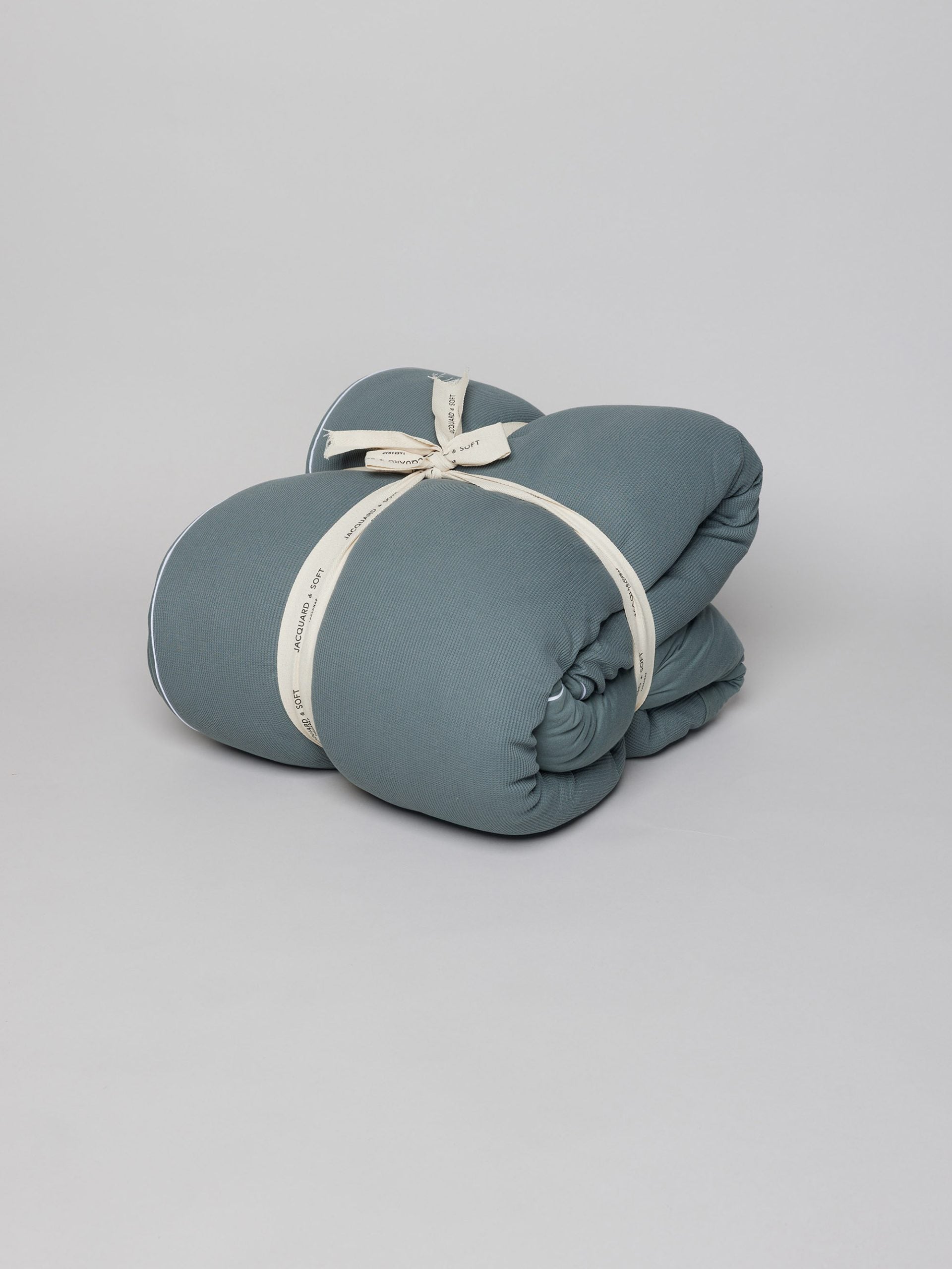 שמיכה למיטה הוליפייבר בצבע אוושן על רקע אפור