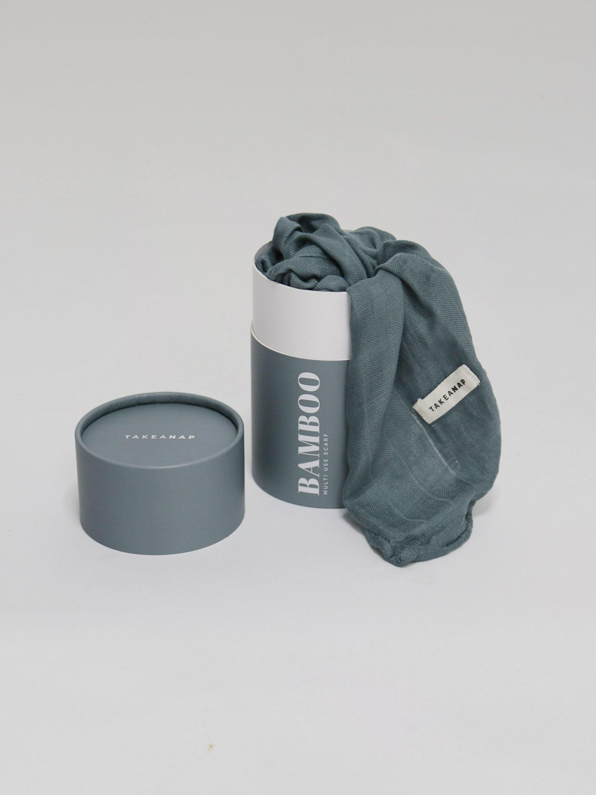 חיתול במבוק בצבע אוושן נשפך מחוץ לאריזה שלו על רקע אפור בהיר בוהק