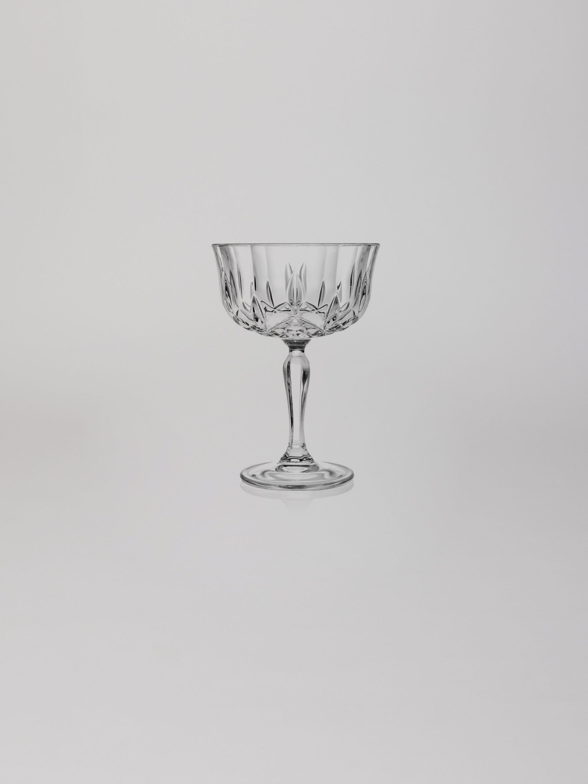 כוס שמפניה מעוצבת על רקע אפור בהיר בוהק