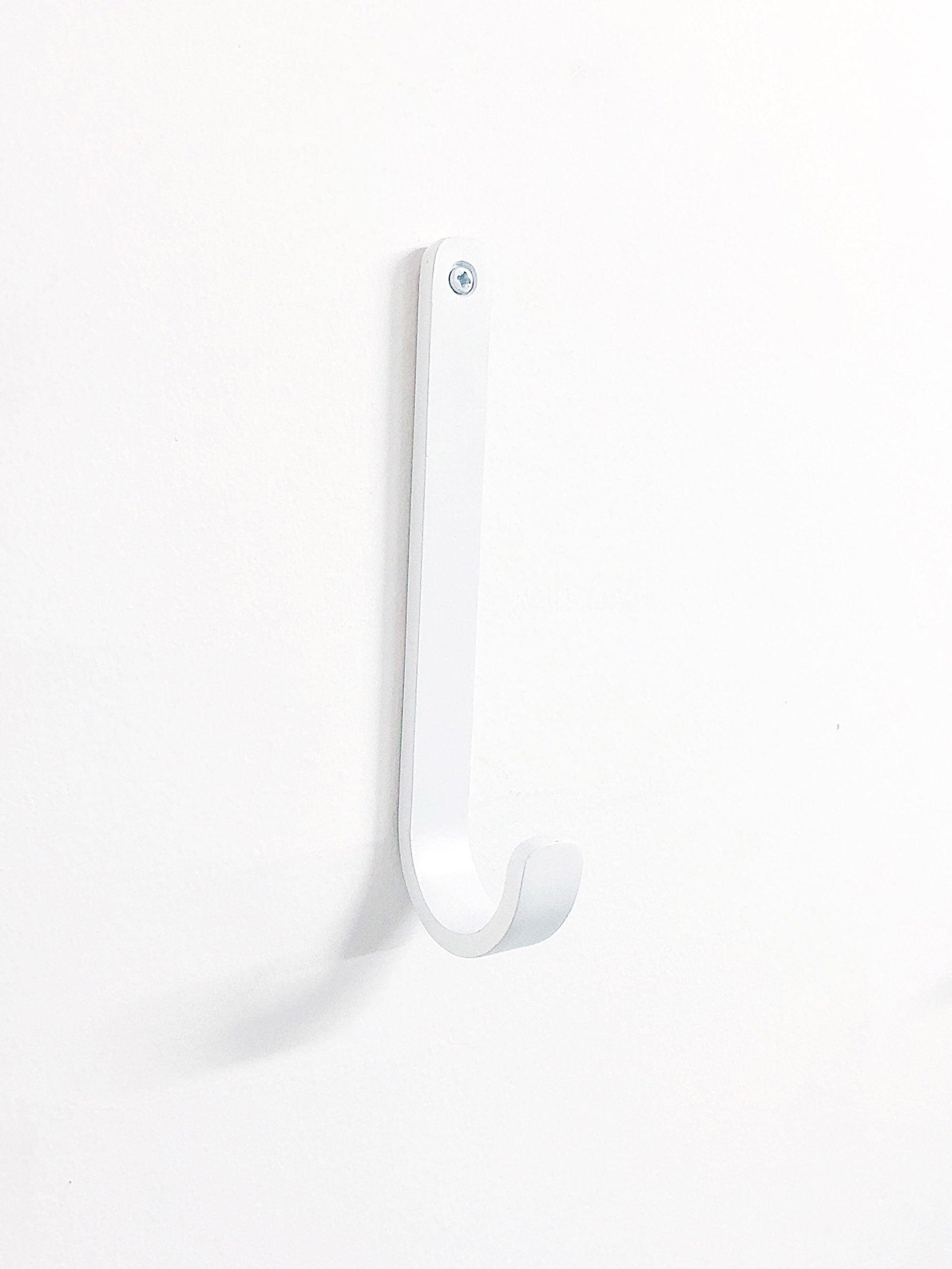 וו תלייה עגול לבן תלוי על קיר לבן