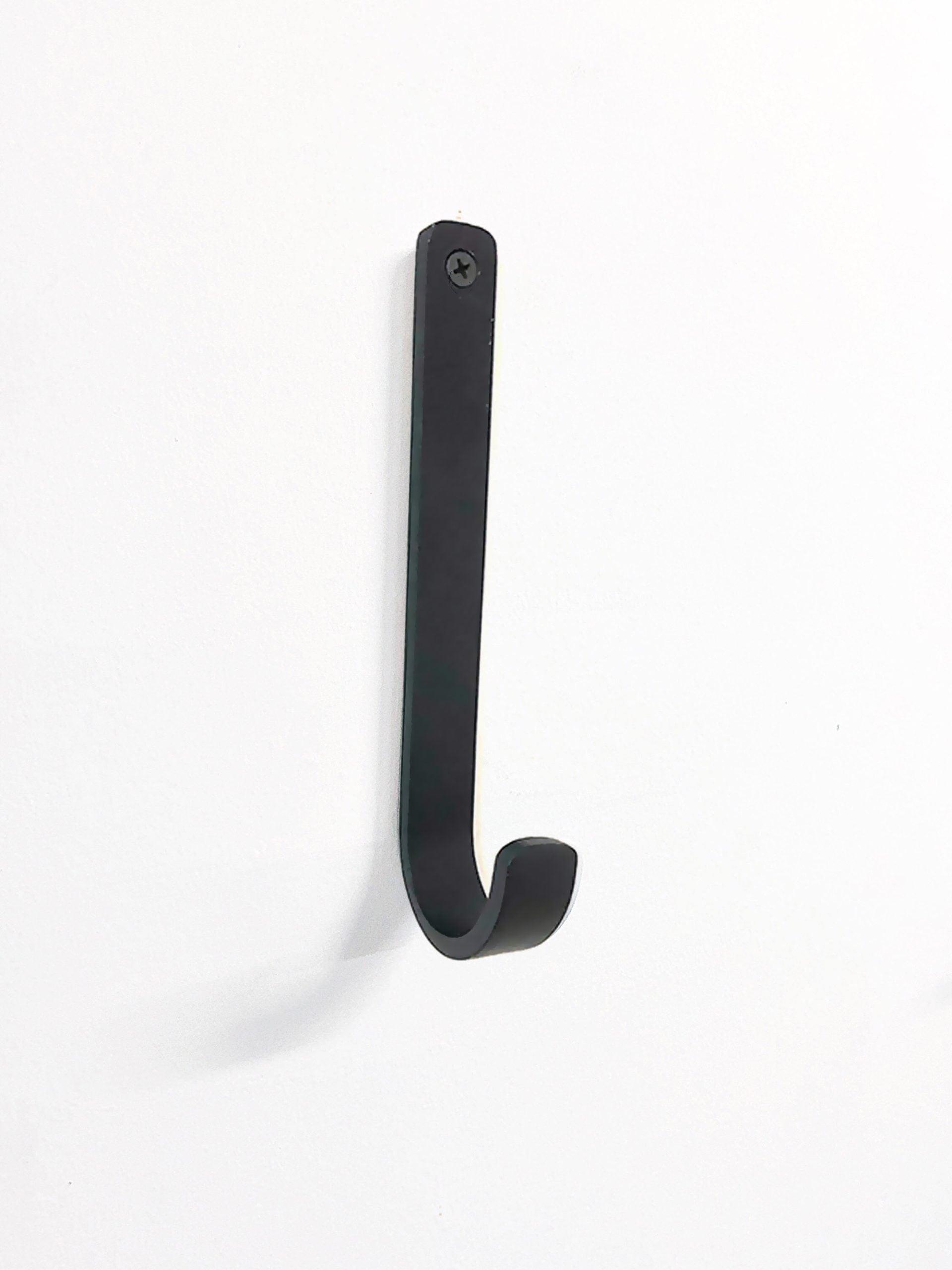 וו תלייה עגול שחור תלוי על קיר לבן