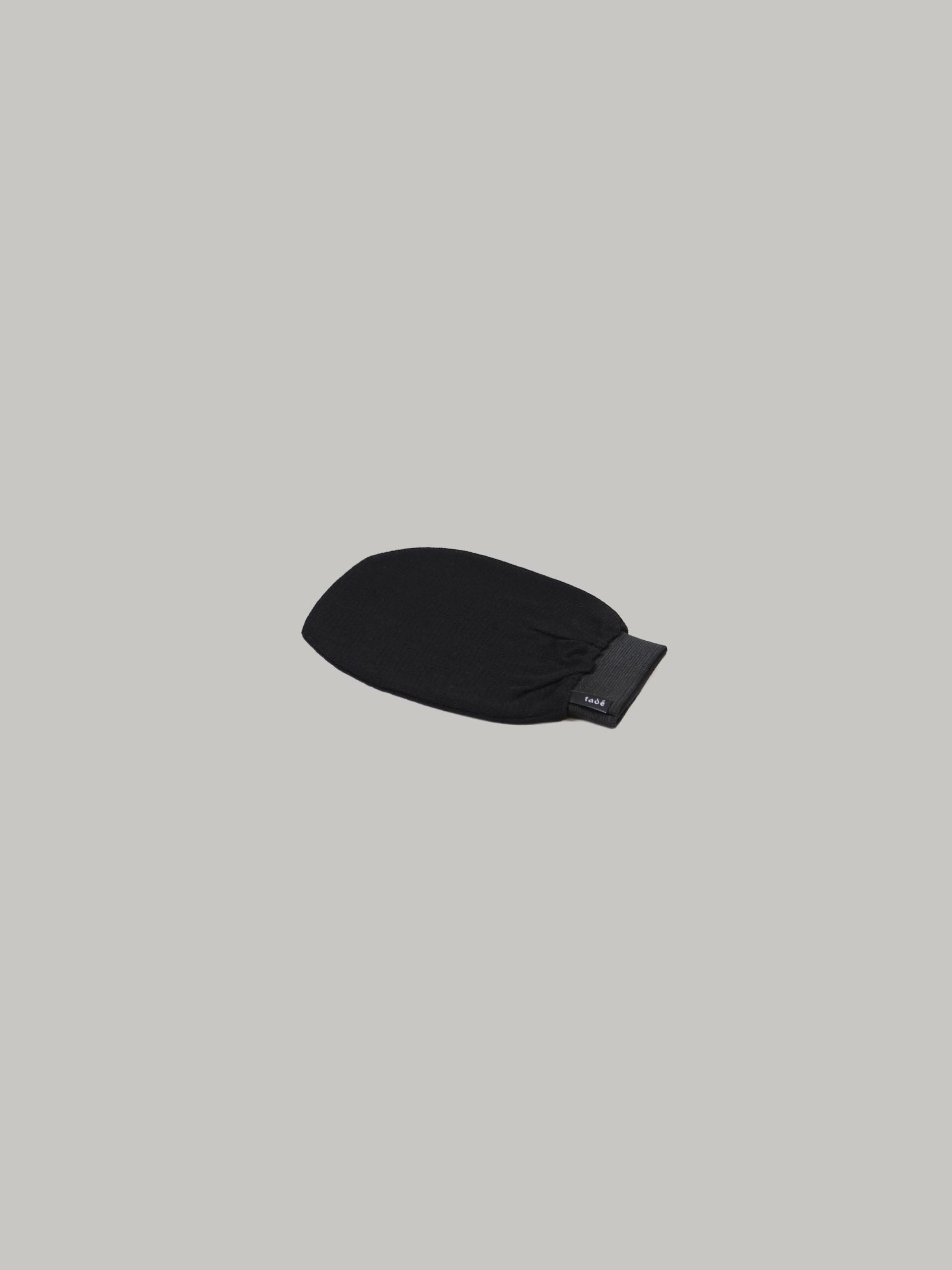 כפפת חמאם לפילינג בצבע שחור על רקע אפור בהיר