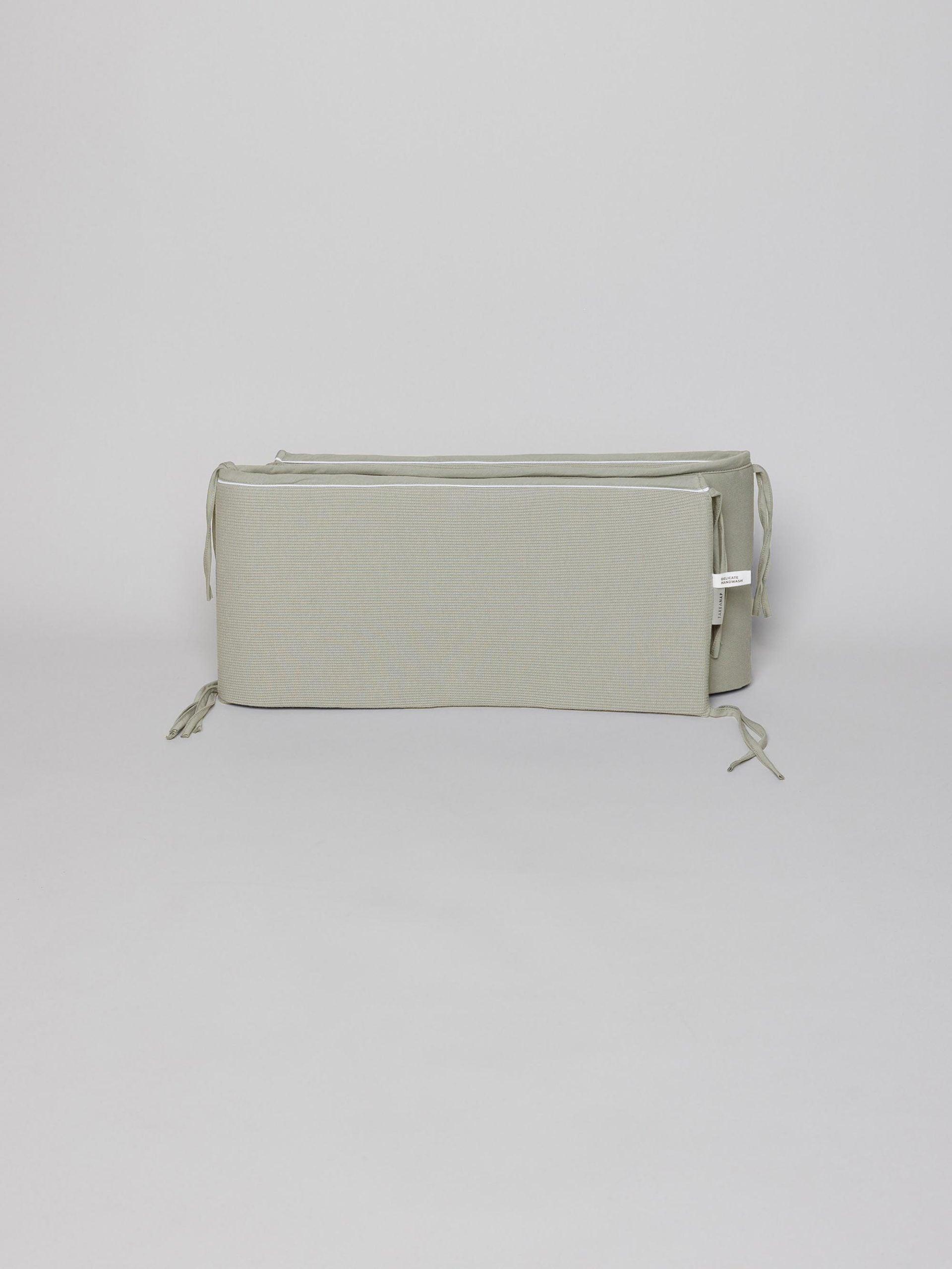 מגן ראש לתינוק ג'קארד בצבע פיסטוק על רקע אפור בהיר