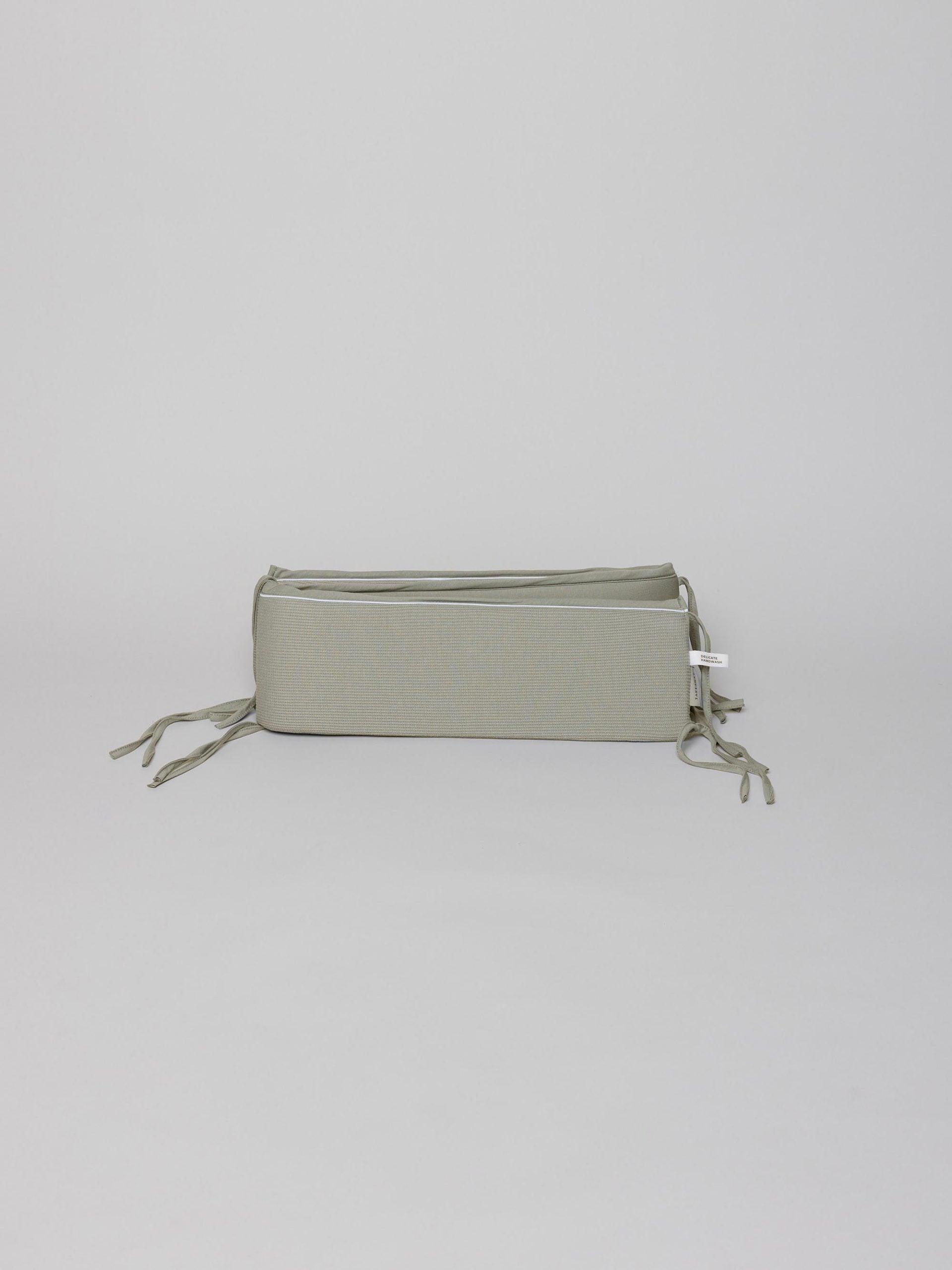 מגן ראש לתינוק ג'קארד בצבע פיסטוק על רקע אפור בהיר