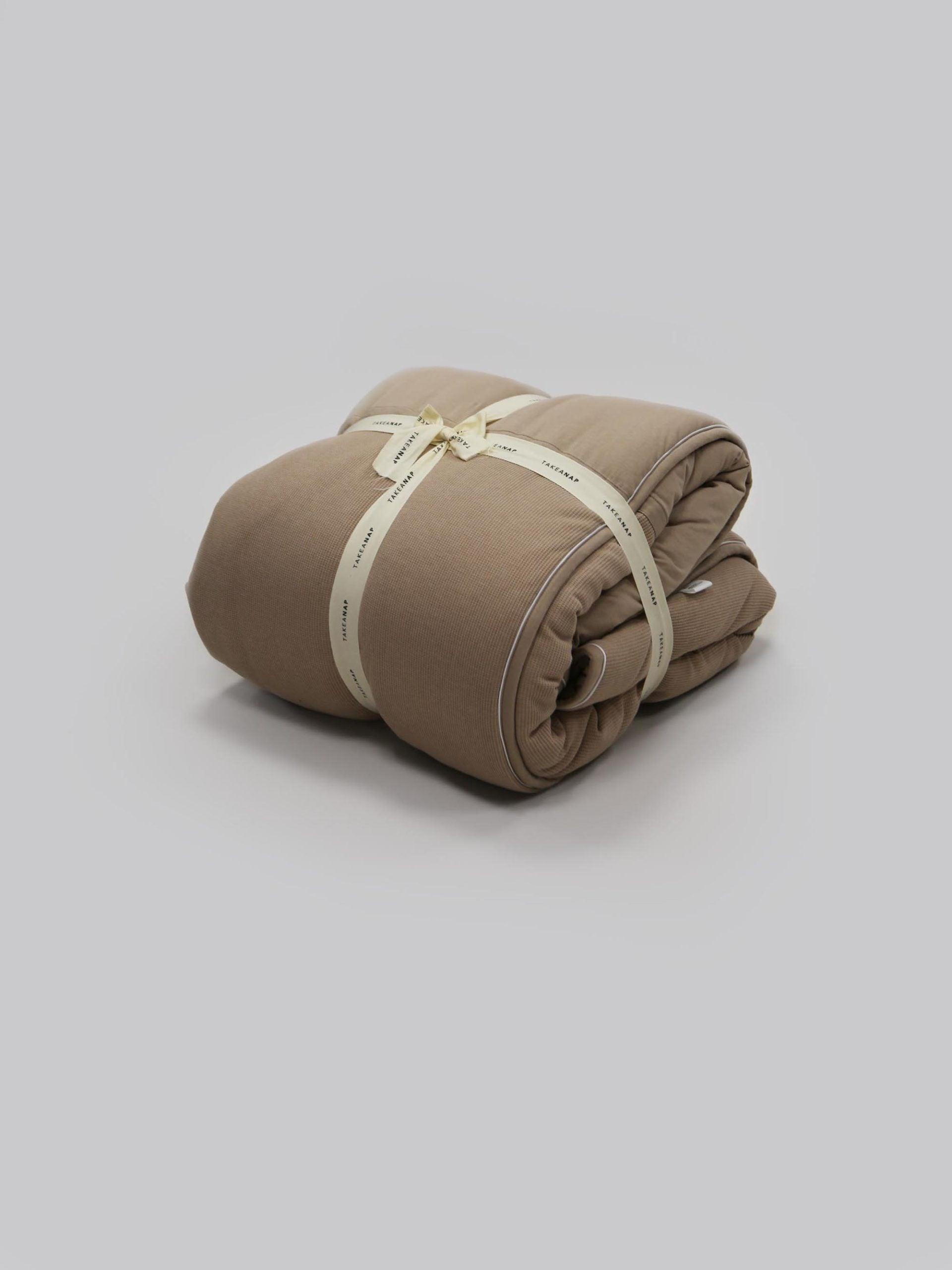 שמיכת חורף הוליפייבר בצבע מוקה על רקע אפור