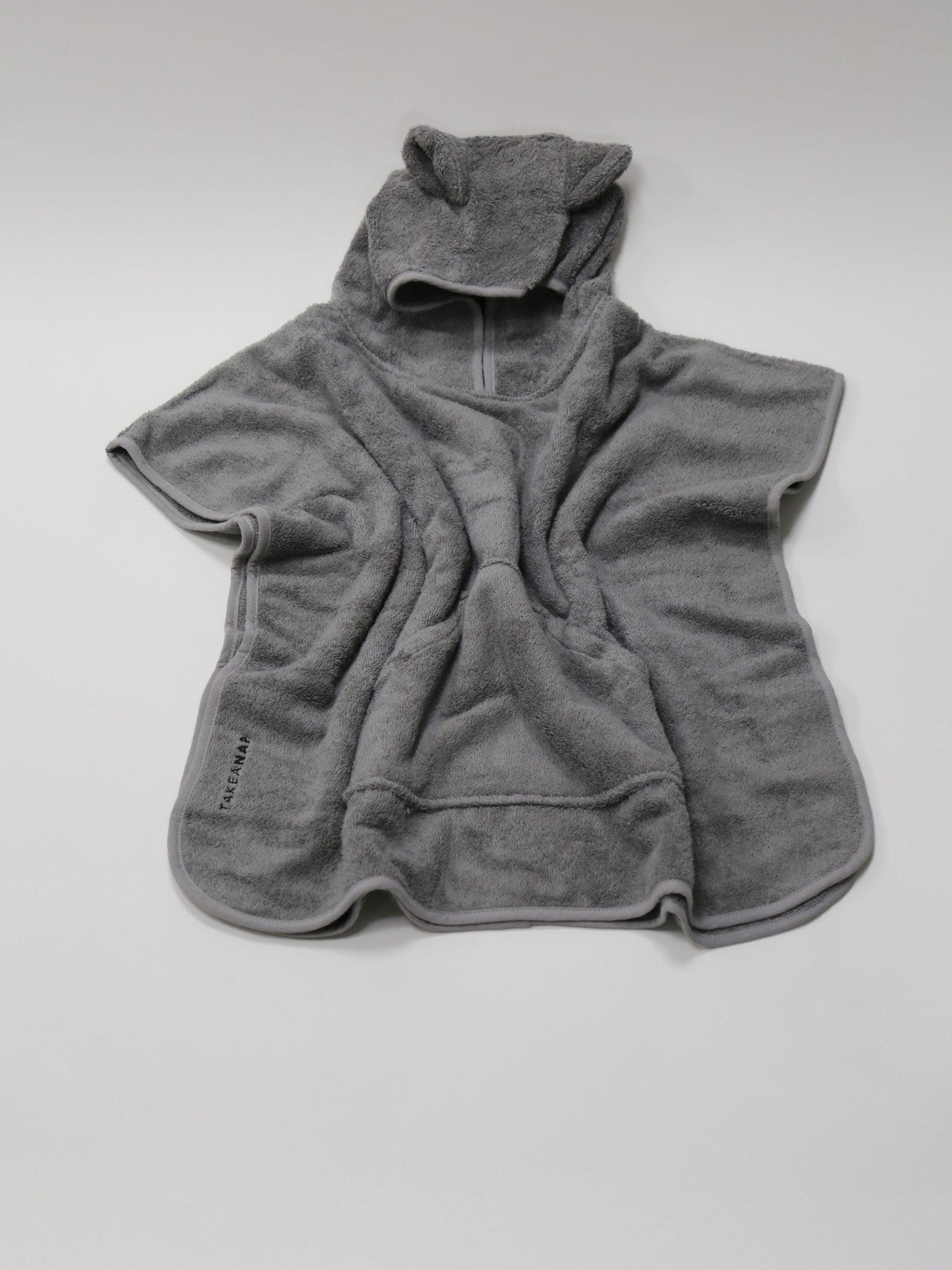 מגבת פונצ'ו לילדים בצבע אפור פרושה על רקע אפור