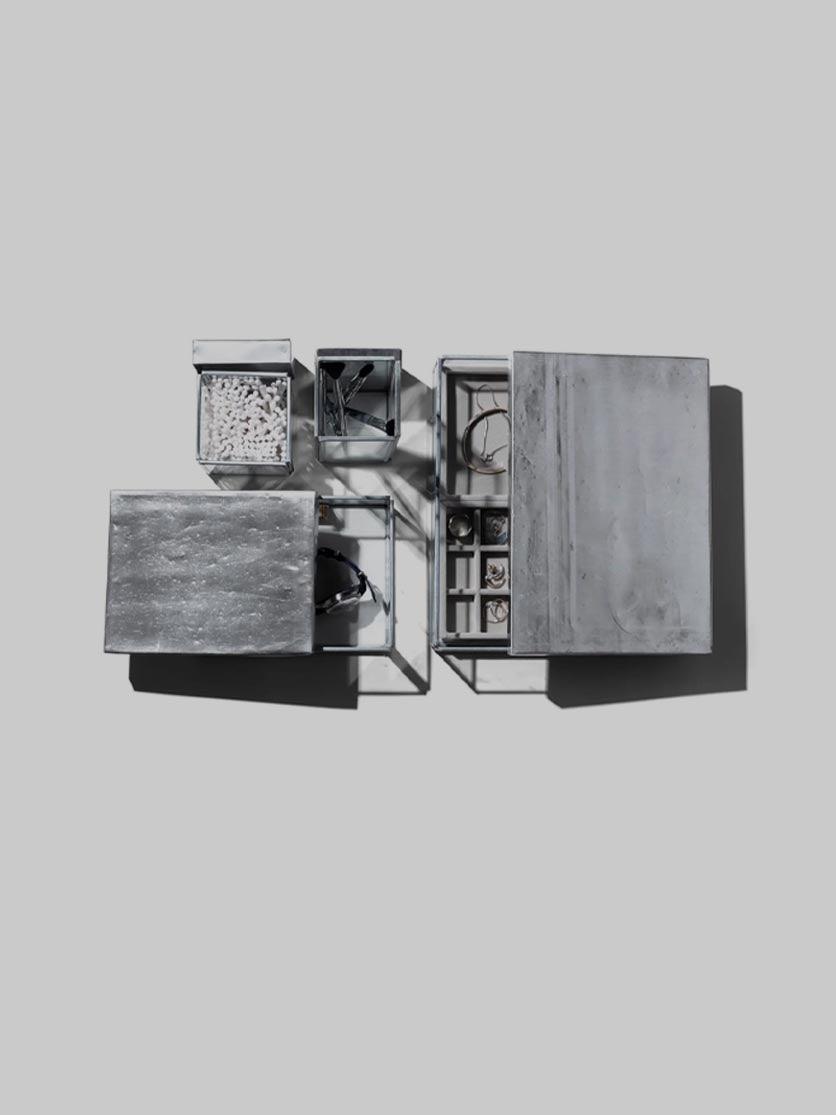ארבעה קופסאות עם דפנות זכוכית בגדלים שונים על רקע אפור בהיר