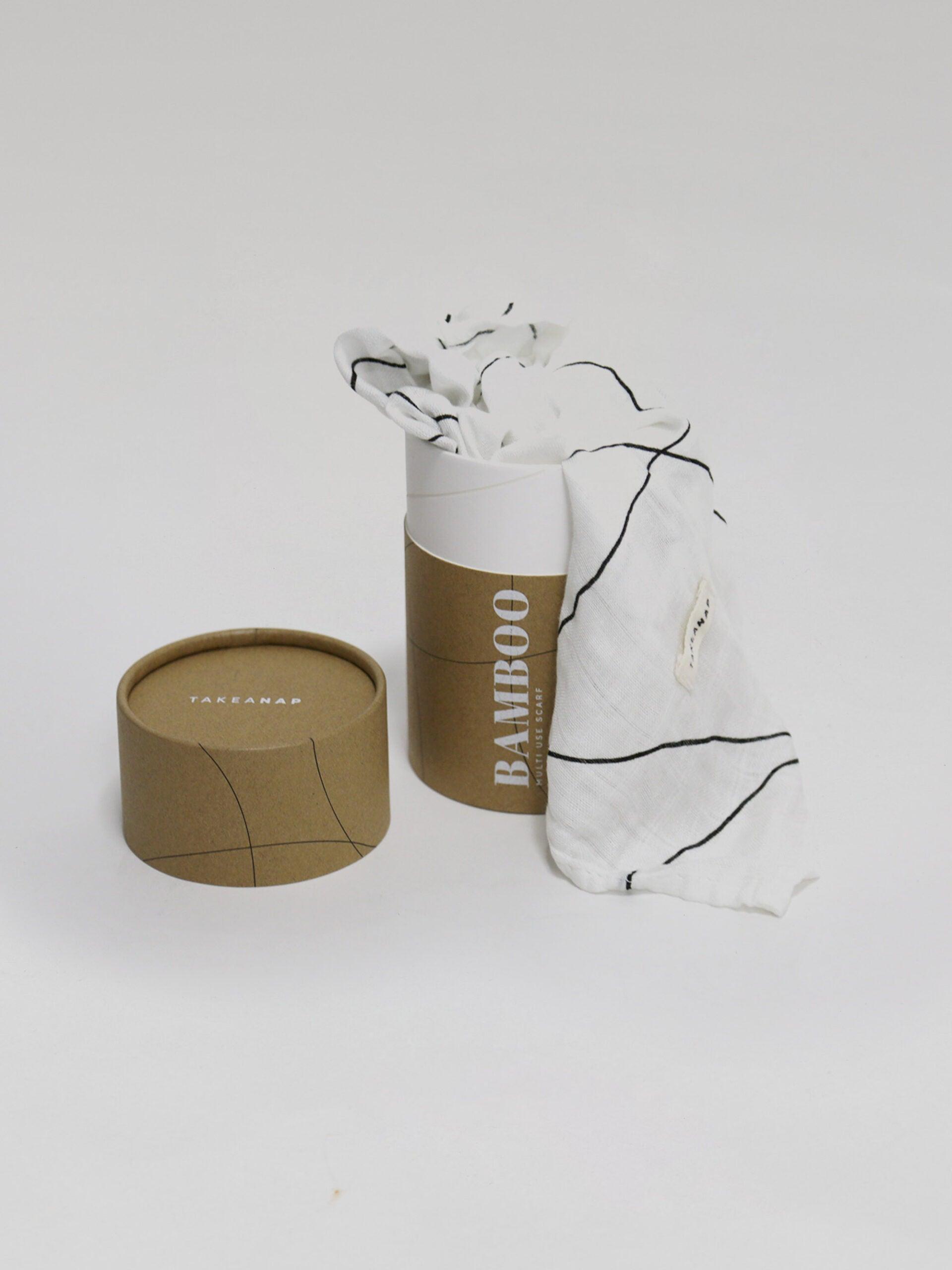 חיתול במבוק בצבע פסים שחור לבן נשפך מחוץ לאריזה שלו על רקע אפור בהיר בוהק