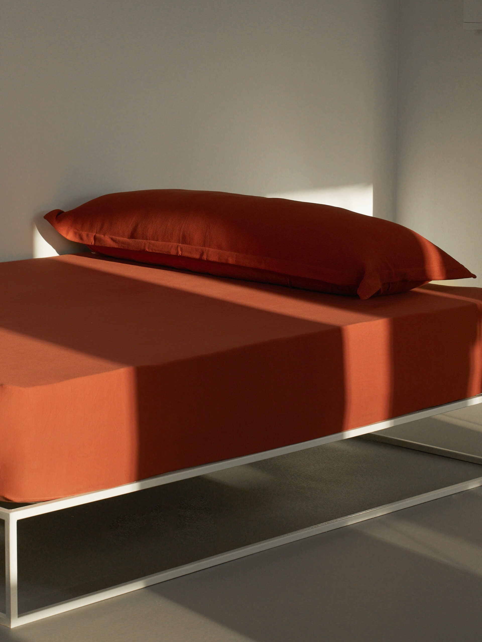 מיטת ברזל לבנה עם סדין, כרית וציפית לכרית ארוכה בצבע טאבקו 