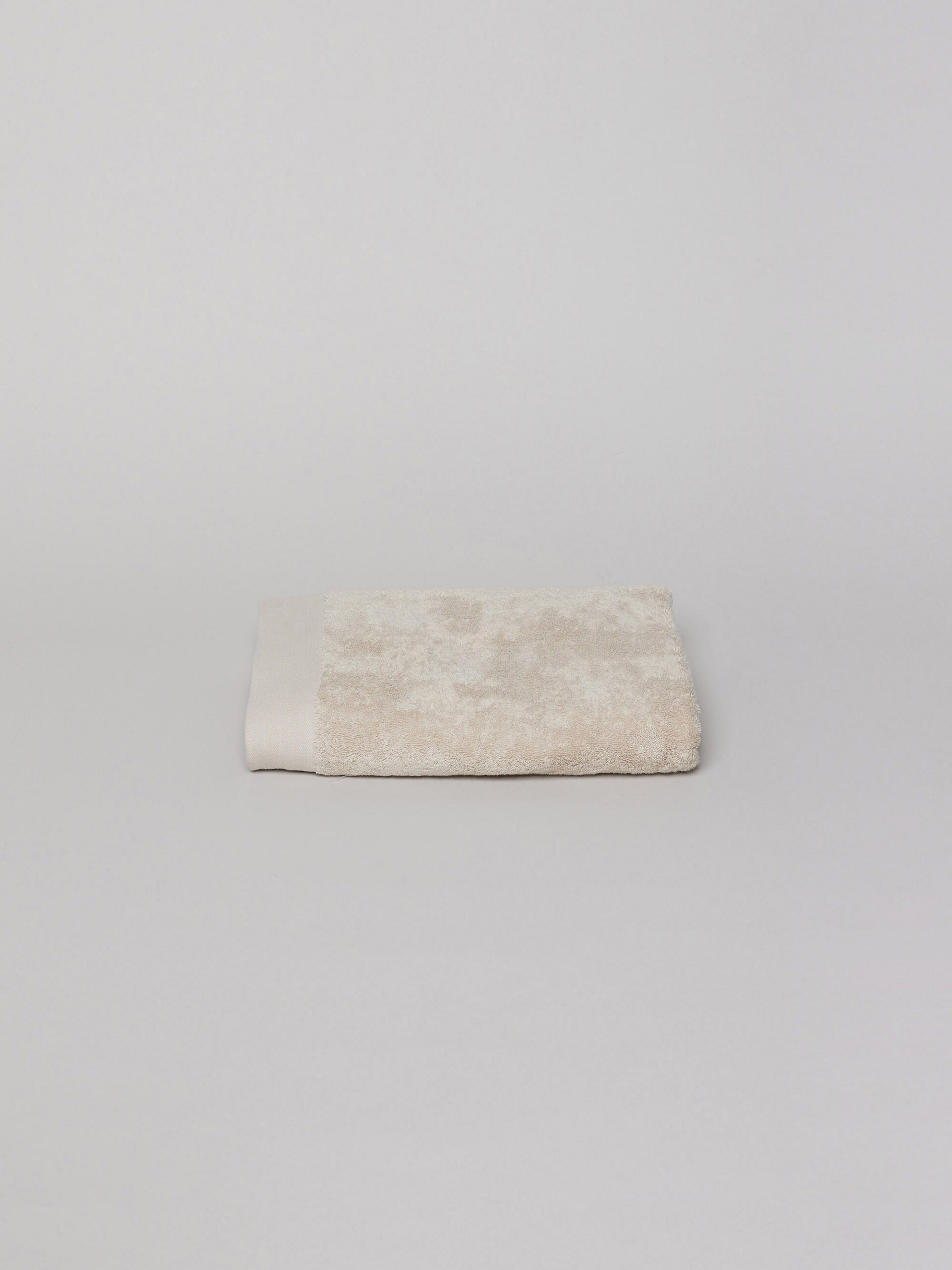 מגבת גוף בגודל בינוני צבע אבן על רקע אפור