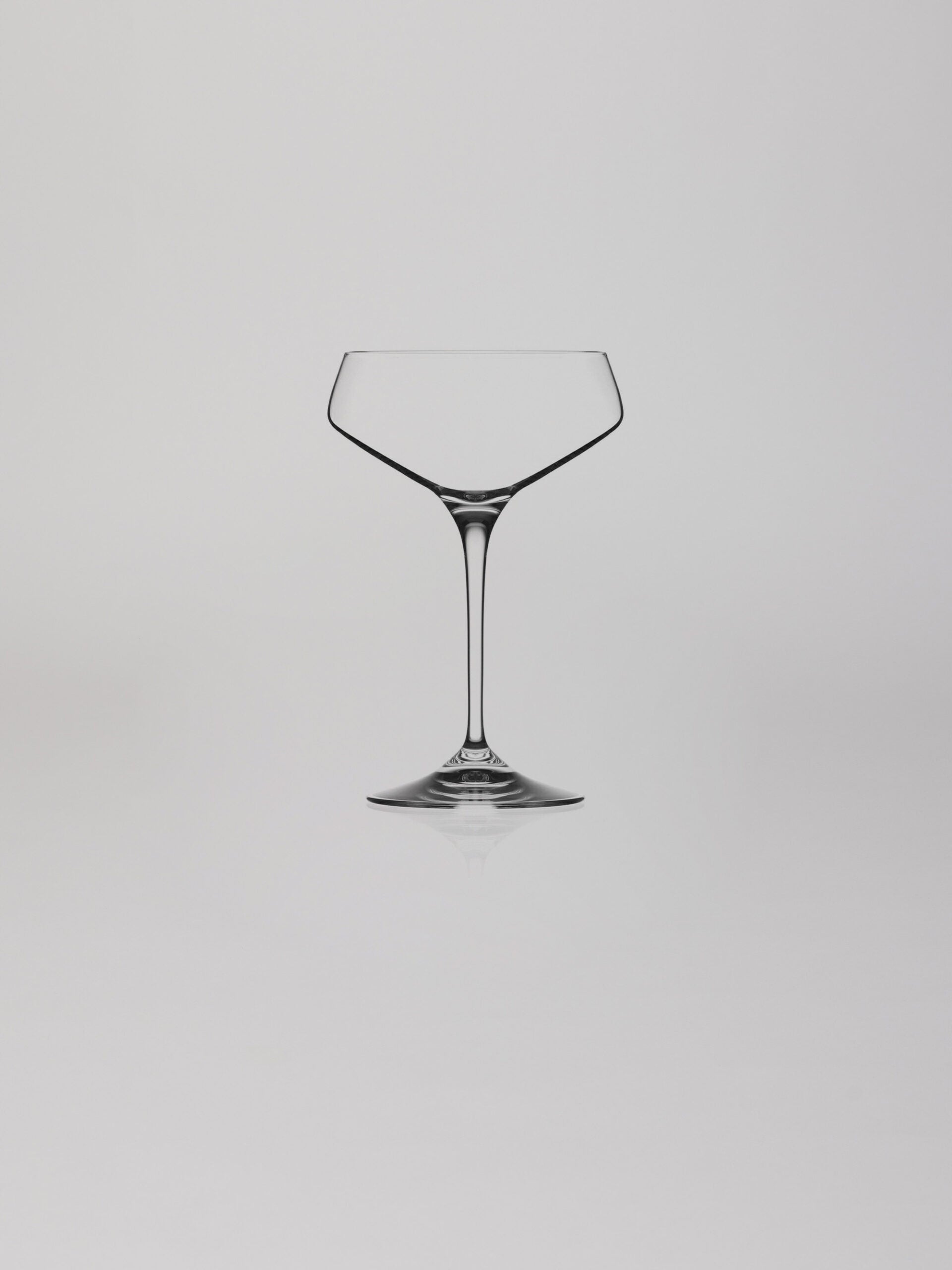 כוס שמפניה על רקע אפור בהיר