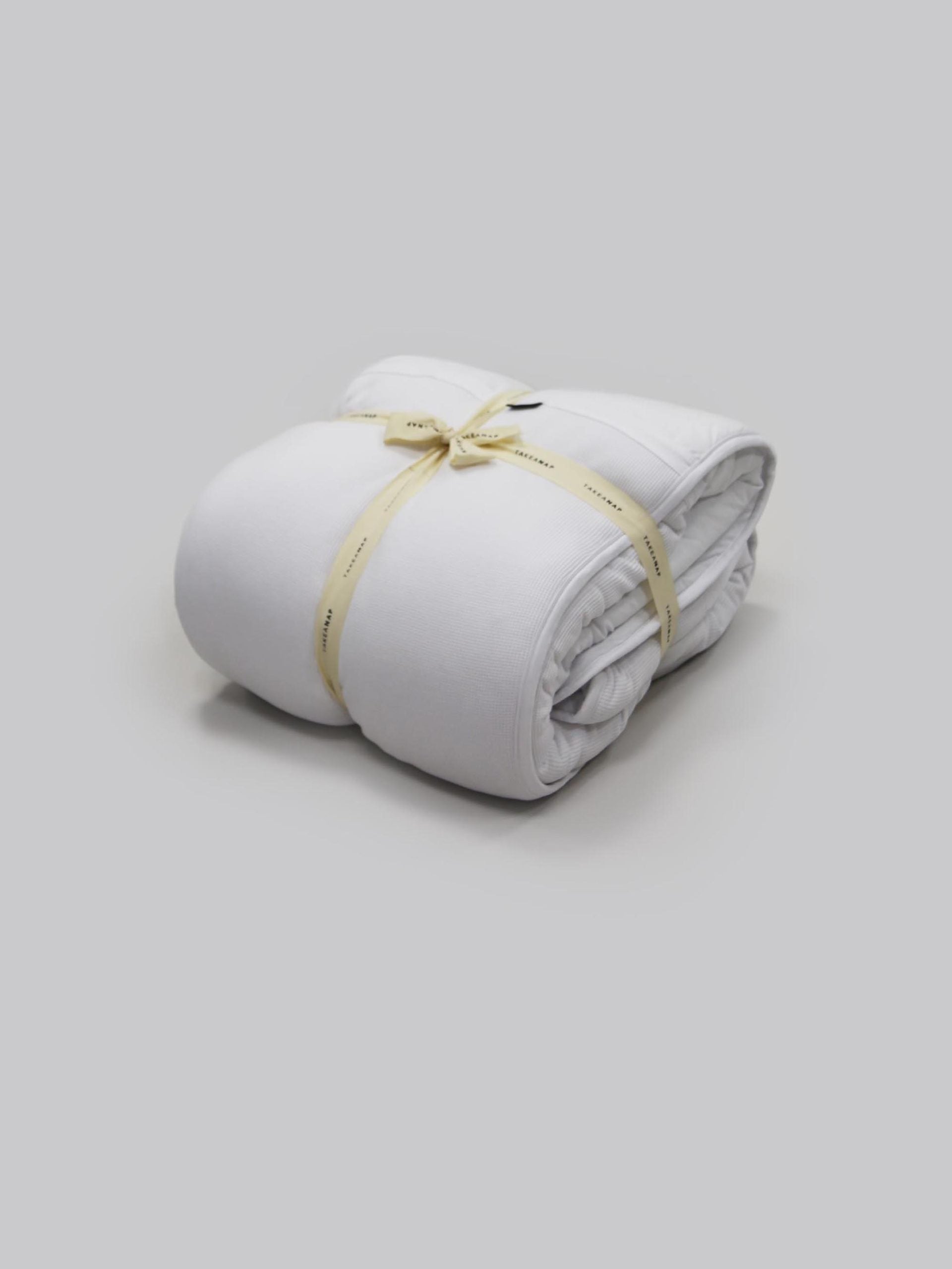 שמיכה מהוליפייבר בצבע לבן על רקע אפור