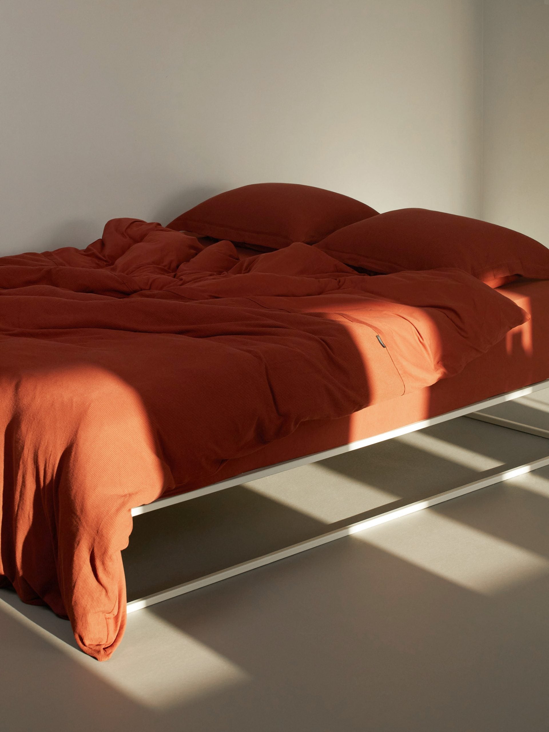 מיטת ברזל לבנה עם מצעים הכוללים סדין, שמיכת פוך עם ציפה לשמיכה כרית וציפית לכרית 